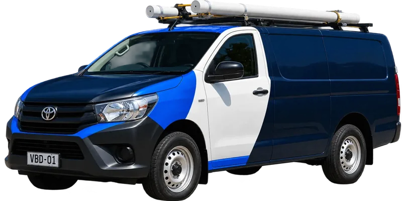 A licensed Manly plumbing van loaded with pipe on the roof rack